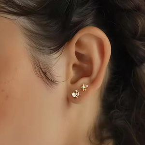 Pendientes de titanio dorado con estrella y luna con circonitas en modelo femenina