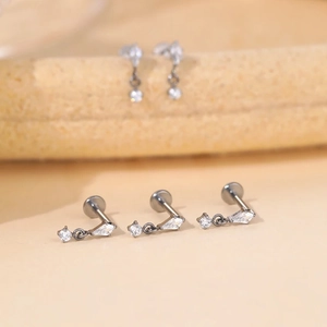 Macro detail of F136 titanium labret earring with sparkling pear-cut zircon and chain
