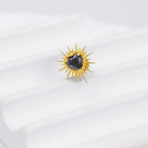 Macro detail of G23 titanium heart earring with black zircon and gold radial spikes