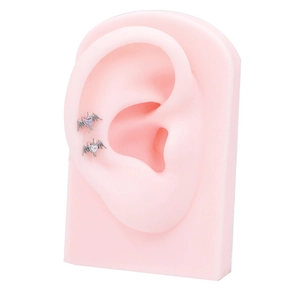Detail of G23 titanium heart bat wing ear studs with purple and clear zircon on ear model