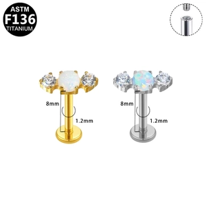 Macro detail of F136 titanium labret studs with opal and zircon in gold and silver