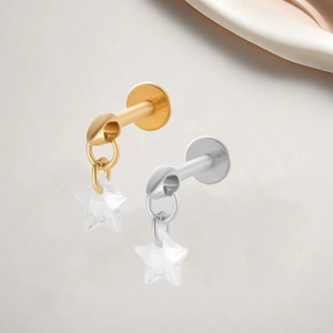 Macro detail van G23 titanium ster zirkoon labret piercing in goud en zilver finish