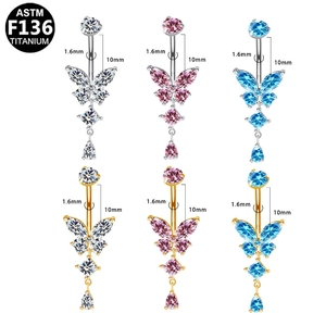Macro detail of butterfly belly rings in G23 titanium with zircon inlay and pendant charms