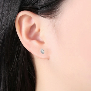 Macro-opname van F136 titanium oorpiercing met marquise opaal en kraalrand detail