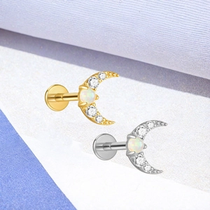 Macro-opname van F136 titanium maansikkel labrets met opaal en zirkoon in goud en zilver