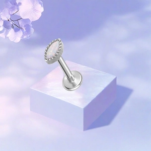 Detail van F136 titanium piercing met ovale witte opaal en iriserende afwerking