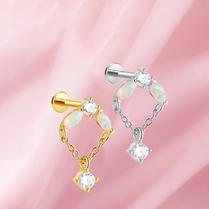 Detalle de piercings de titanio con opale marquesa y cadena colgante de circonitas lujo