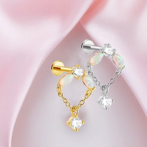 Detalle de piercing labret de titanio con ópalo marquise y cadena colgante de circón