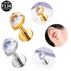Macro detail of ASTM F136 titanium pear shape zircon stud earrings in gold and silver