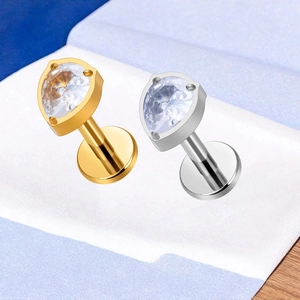 Detail of F136 titanium labret studs with pear-cut zircon in gold and silver finish