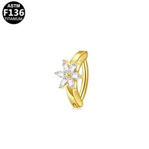 Bauchpiercing aus ASTM F136 Titan in Gold mit Blume aus Markasit-Steinen auf weißem Grund