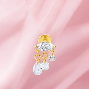 Detalle de pendiente de titanio dorado con cristales de talla marquesa y gota colgante
