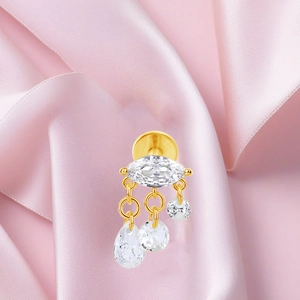 Detalle de pendiente de titanio F136 dorado con circonitas blancas en forma de marquesa