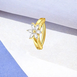 Detail eines goldenen Bauchnabelpiercings mit Blütenblatt-Zirkonia im Marquise-Schliff