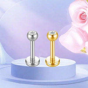 Detail of silver and gold F136 titanium stud earrings with sparkling round zircon inlays