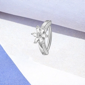 Makroaufnahme von F136 Titan Bauchnabelpiercing mit Blumenmotiv und klaren Zirkoniasteinen