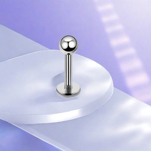 Detailed view of polished F136 titanium labret stud with ball top and flat disk base