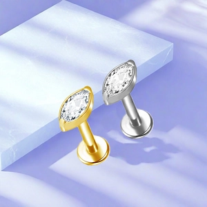 Detailed macro view of marquise-cut zircon flat back labret studs in gold and silver