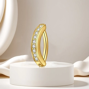 Makro-Detail eines goldenen Bauchnabelpiercings mit acht funkelnden Zirkonia-Steinen