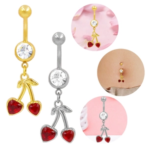 Dettaglio macro di piercing all'ombelico a ciliegia a forma di cuore in argento e oro