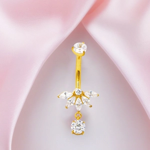Detalle de un piercing de ombligo de titanio dorado con flor de circón y colgante