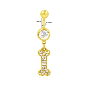 Dettaglio del piercing all'ombelico dorato con zircone e pendente a osso con cristalli