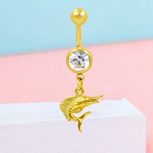 Detail of golden stainless steel belly ring featuring a marlin fish pendant and zircon stone