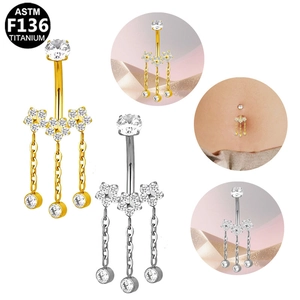 Detalle del piercing de ombligo en titanio ASTM F136 con flores de circonia y cadenas