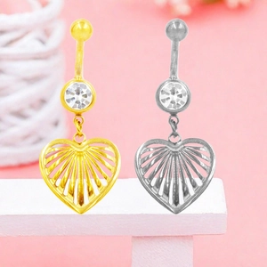 Dettaglio di piercing all'ombelico a forma di cuore in oro e argento con zircone