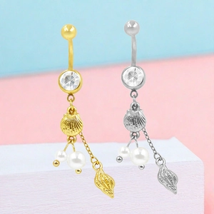 Dettaglio di piercing all'ombelico in oro e argento con ciondoli a conchiglia e perla