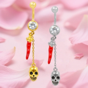 Dettaglio dei piercing all'ombelico con ciondoli a peperoncino e teschio oro e argento