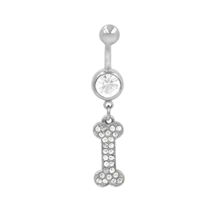 Dettaglio di un piercing all'ombelico in acciaio con ciondolo a forma di osso e strass chiari