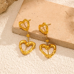 Lavatexturierte 18k Gold Herzohrringe mit hohlem Design auf Travertin-Hintergrund