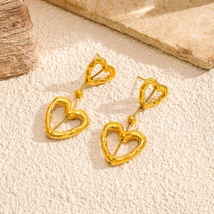 Detaillierte Makroansicht von 18k Herzohrringen mit Lava-Struktur auf Steinoberfläche