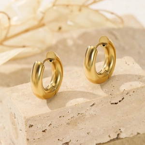 Polished 14K gold plated stainless steel chunky hoop earrings on a textured stone base