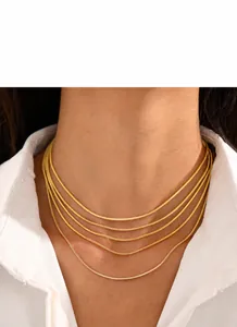 Gros plan d'un collier élégant doré à plusieurs rangs en maille serpent sur un mannequin