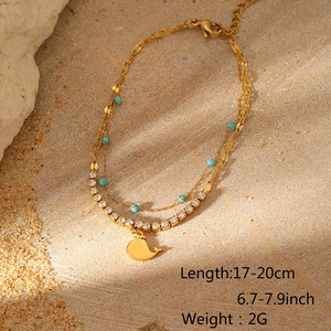 Detail einer vergoldeten Fußkette mit türkisen Perlen, Zirkonia-Kette und Walflossen-Anhänger