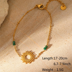 Detailaufnahme der goldenen Edelstahlkette mit Sonnenanhänger und grünen Perlenbesatz