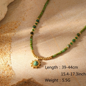 Detail der Perlenkette mit grünen Steinen und Sonnenanhänger, Länge 39-44 cm
