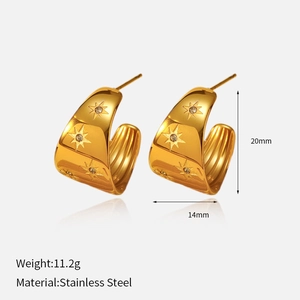 Détail de boucles d'oreilles créoles en acier poli avec gravure d'étoile et cristaux