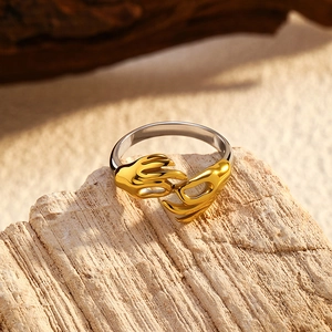 Détail macro d'une bague bicolore en acier inoxydable avec motif mains dorées