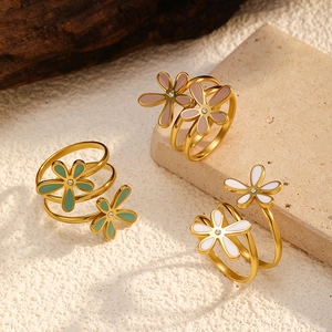 Detailed view of colorful enamel daisy rings on stones with 18K gold plated finish
