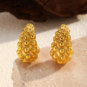 Vista macro de pendientes de gota huecos bañados en oro con textura de burbujas única