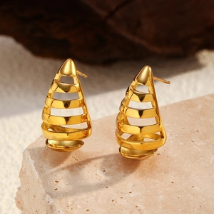 Detalle de pendientes de gota calados en acero inoxidable chapado en oro 18K sobre piedra