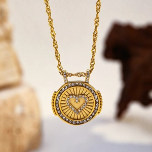 Gros plan du pendentif cœur doré serti de cristaux brillants avec une texture rayonnante