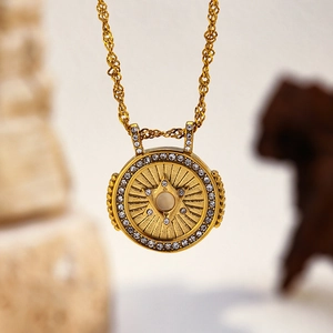 Collier médaillon rétro doré avec centre perle et halo de strass sur une chaîne de corde fine