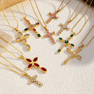 Detailed view of 18K gold plated cross necklaces with colorful zircon stones on stone background