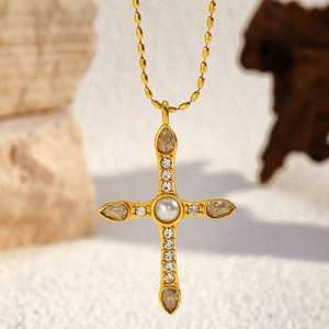 Detail of vintage 18K gold plated cross pendant with pearl and sparkling crystals
