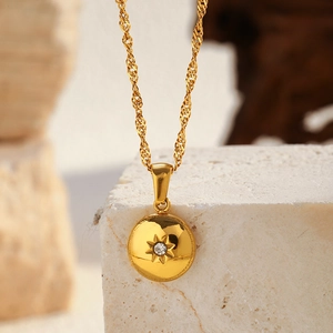 Vue détaillée du pendentif médaillon doré avec motif étoile et zircon blanc incrusté