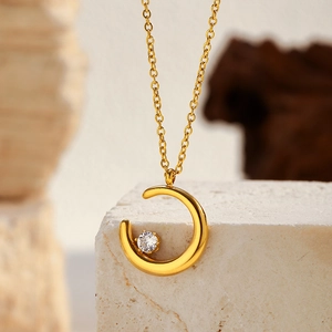 Détail du collier pendentif lune doré avec zircone incrustée sur une pierre texturée